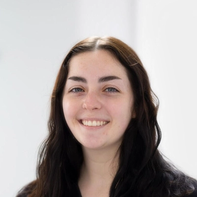 Dental Assistant Emma Smiling In Front Of Blurred Background