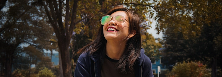 Girl At A Park Looking Up Smiling