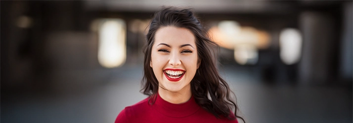 Girl Smiling In Front Of Blurred Background