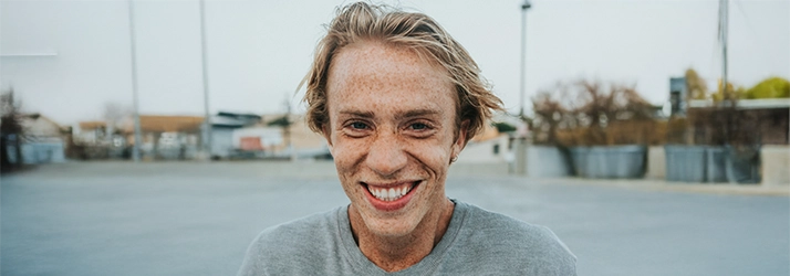 Man With Freckles In Grey Shirt Smiling